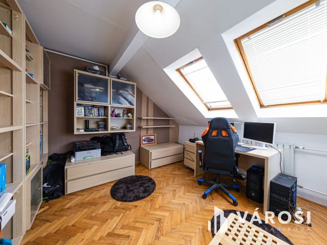 Látszó fagerendás tetőtéri lakás csendes utcában