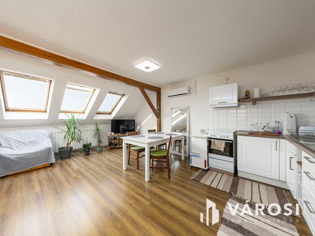 Látszó fagerendás tetőtéri lakás csendes utcában